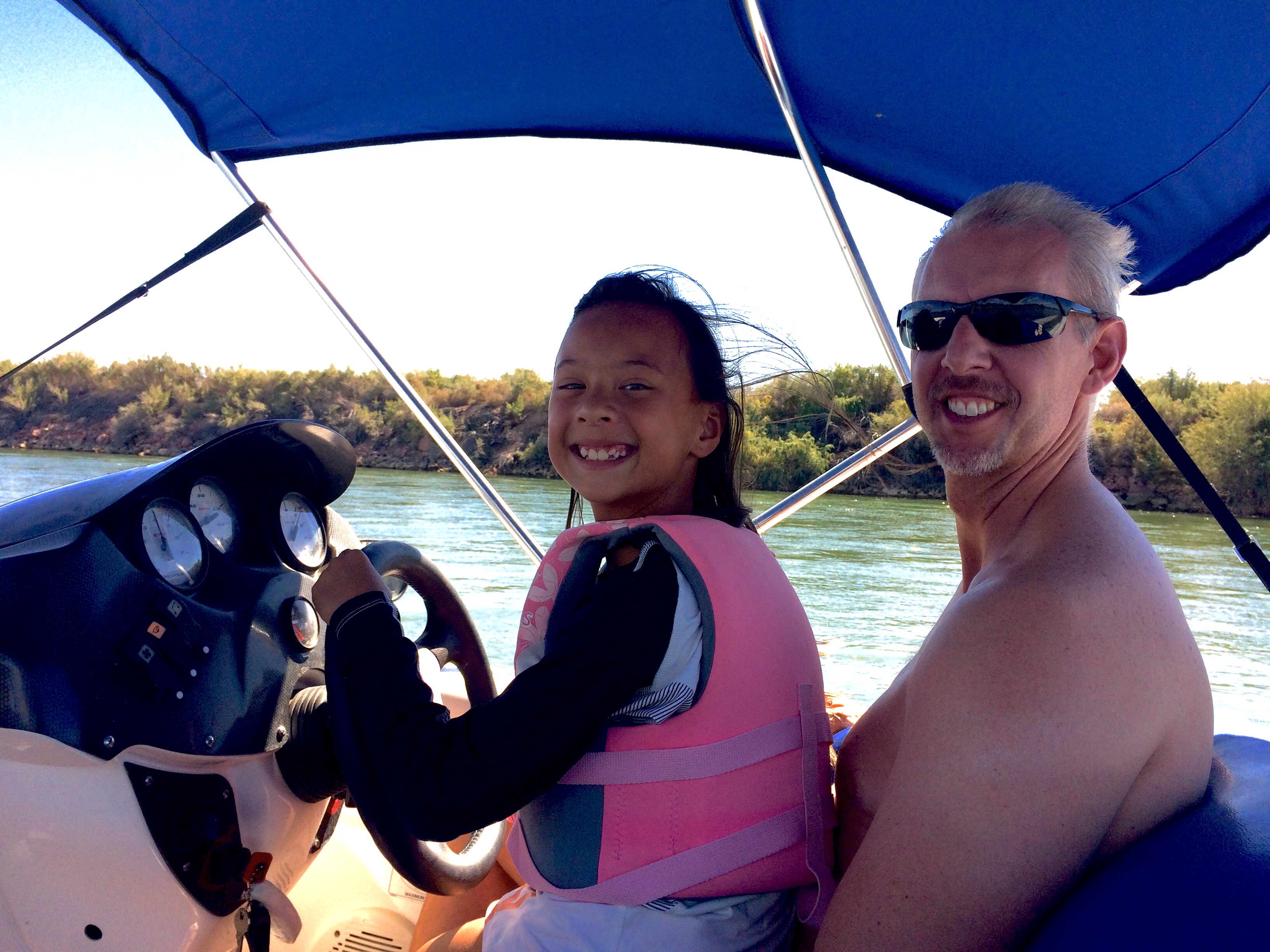 Emma driving the boat with Sean, on the river