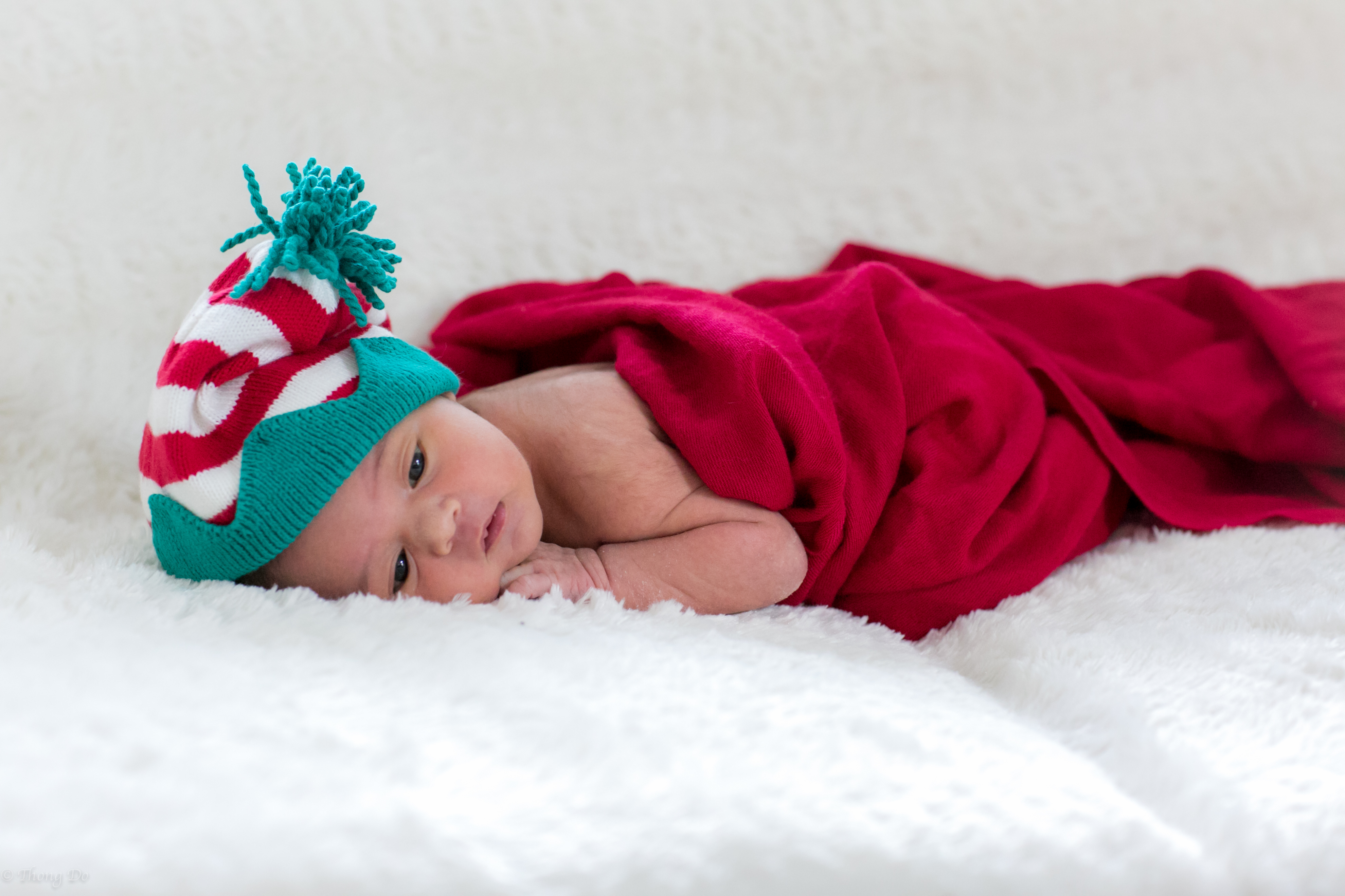 Newborn Riley in a red and teal knit hat