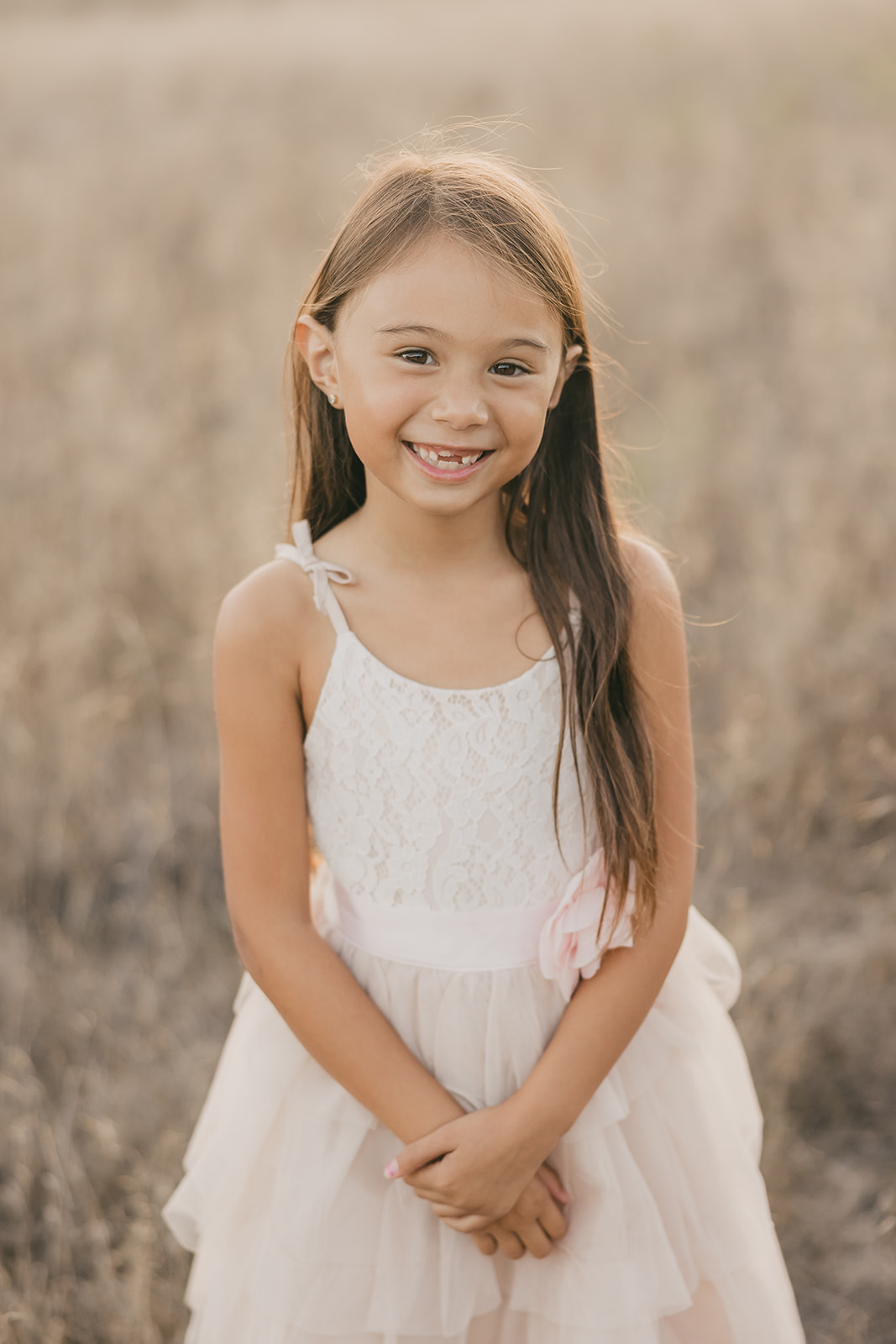 One of the girls smiling in the golden field